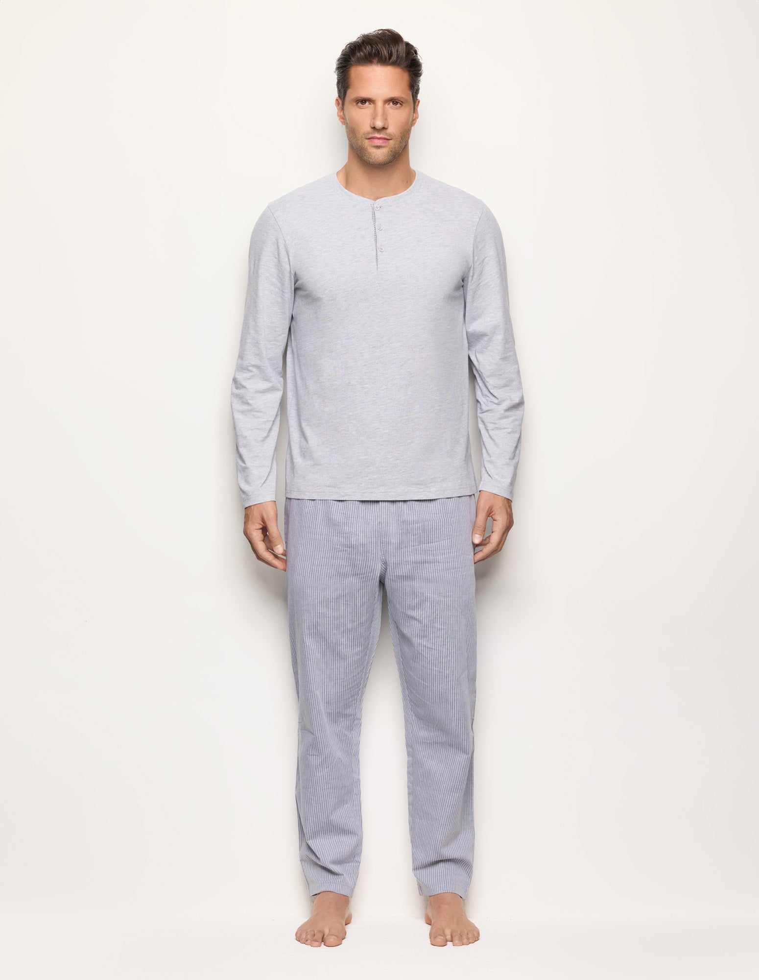 Man wearing a gray pajama set on a white background